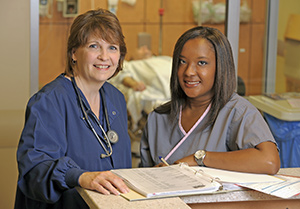 two people in a hospital setting reviewing paperwork