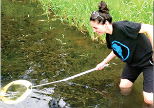 woman in the water with a skimmer 