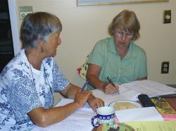 Two women taking notes.