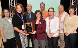 CCME President Joycelyn Groot presented 2013 Institution Award. Seen in the front row left to right: Mindy Boenning, communication and development coordinator, Joycelyn Groot, CCME president, Linda Frank, Desiree Drindak, Susan Bruce. Seen in the back row left to right, William Yaeger, Charles Van Vorst, and William Mayeaux.