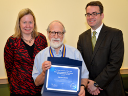 Acting President Meg Benke and Center for Distance Learning Dean Tom Mackey present CDL Director of Academic Review Bernard Smith, center, with the Chancellor’s Award for Excellence in Professional Service.