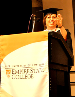 Commencement speaker Carol Evans ’77, Genesee Valley Center, reveals to one and all how she got a kiss on the cheek from President Obama at the White House. She completed all the students on achieving an important milestone in their lives, completing their degree.