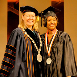 Acting President Meg Benke congratulates student speaker Carol Faulkner ’13.