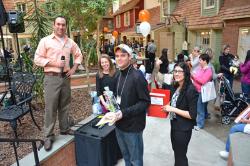 Empire State College’s Andy Binder, standing at left with mic, is all smiles after giving Peter Livshin, a student from Syracuse, the raffle prize he won at the Student Wellness Retreat. Photo/Empire State College