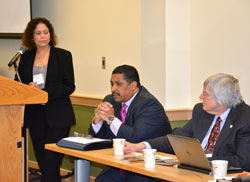 Faculty mentor Audeliz Matais, at the podium, opens “The Future of STEM: Women and Minority Adult Students 2014 Conference.” Carlos Medina, associate provost and associate vice chancellor for the Office of Diversity, Equity and Inclusion at SUNY System Administration, addresses the audience as Joseph Skrivanek, who heads the SUNY Replication Project looks on. Photo/Empire State College