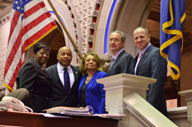 Elected officials join associate professor Catherine Collins, at center, after her unanimous election to the Board of Regents during the annual joint session of the state Legislature. Assemblywoman Crystal Peoples-Stokes stands at far left with state Assembly Speaker Carl E. Heastie, Collins, Assemblyman Sean Ryan and state Sen. Timothy M. Kennedy on the assembly chamber dais. Photo/NY Assembly