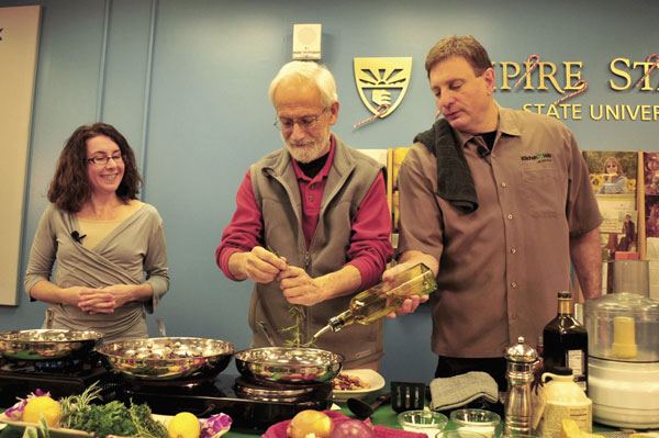 Alumnus Mike Russo ’10, far right, helps Mentor Sylvain Nagler during a Plaza office cooking workshop titled ”Healthy Habits for the Holidays.” 