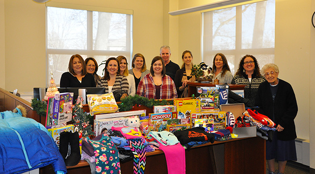 Pictured are the staff of the college's Office of Admissions in front of gifts to be donated to the Empty Stocking Project in Saratoga Springs.