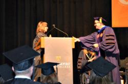 Student speaker Michelle Dendera is congratulated by Vice Provost Tom Mackey at the college's commencement event at Purchase College.